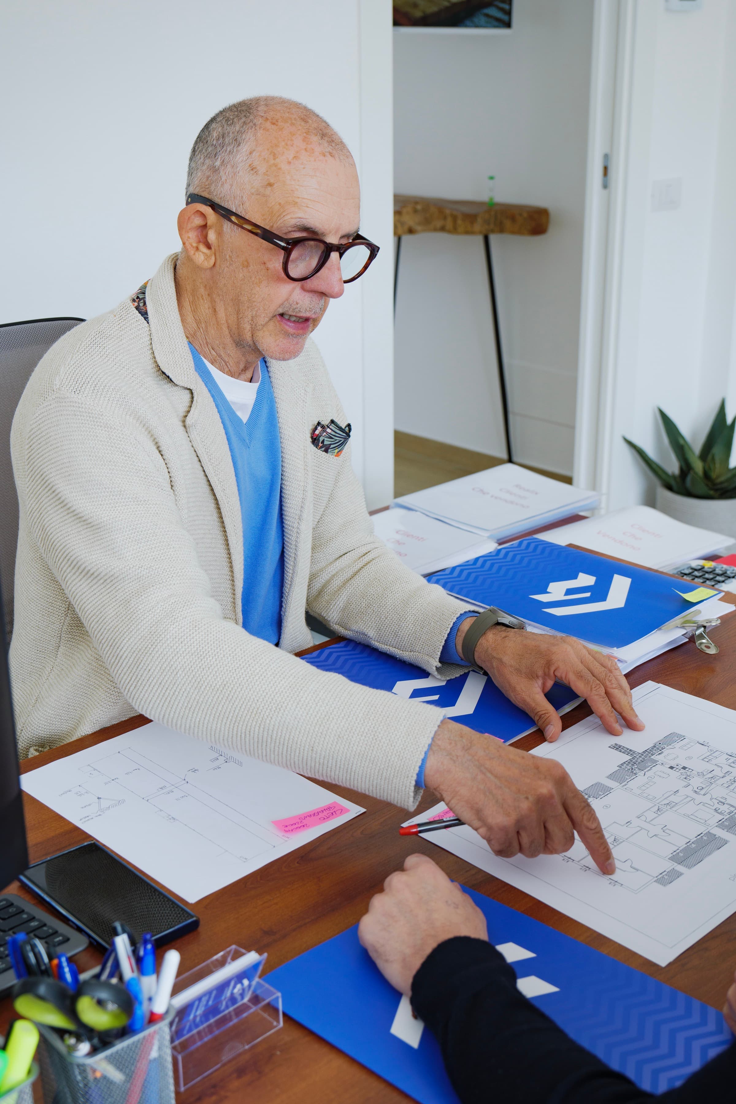 Lorenzo Faetanini durante una consulenza con planimetrie sul tavolo